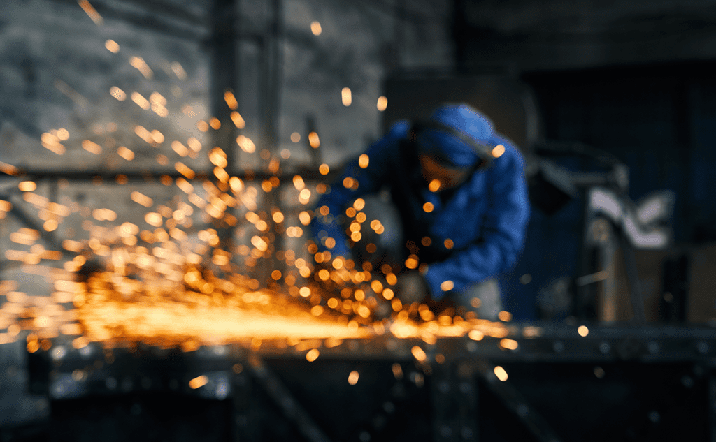 Employee grinding stainless steel used as a featured image on a blog about stainless steel grades.